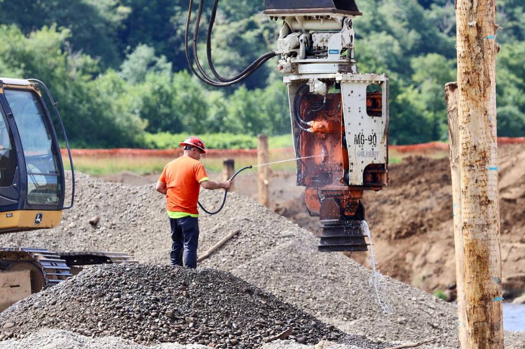 Michael S. Lockett / The Daily World
A worker sprays water on machinery at a river conservation project on the Satsop River.