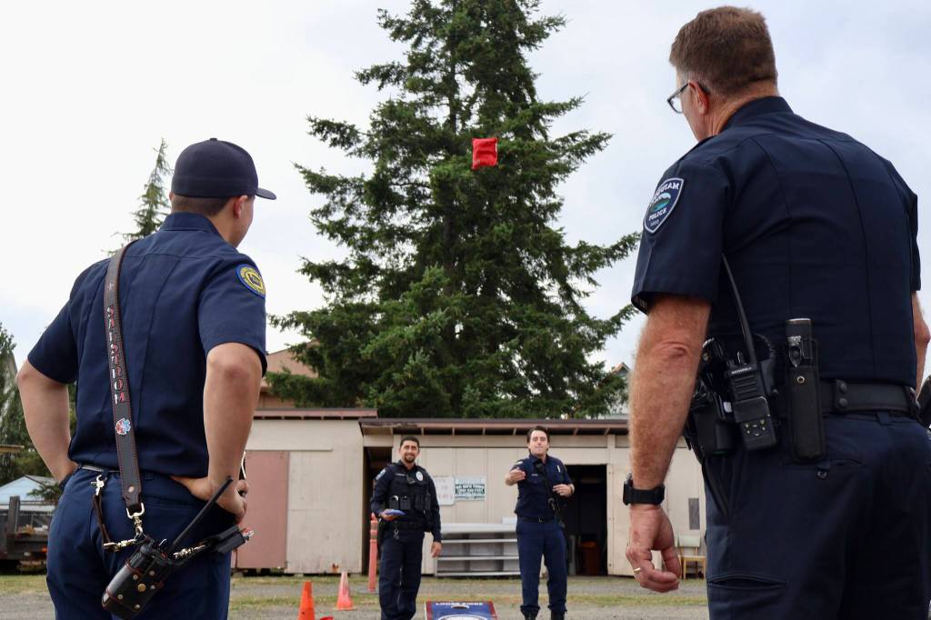 Michael S. Lockett / The Daily World
Hoquiam police and firefighters engage in a cornhole match during a National Night Out event in Hoquiam.