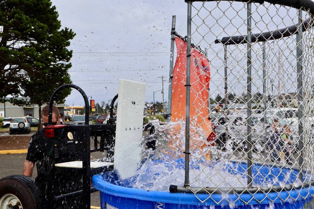 Sgt. Daniel Fode is elected to embrace the depths during a National Night Out event in Ocean Shores. (Michael S. Lockett / The Daily World)