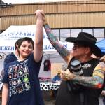 Matthew N. Wells / The Daily World
Right after Rick Moyer, left, announced the winner of the watermelon eating contest  the 9-12-year range  he held up Eden Felders fist up like he was announcing the winner of a title fight. Felder said he was trying to eat the watermelon with huge bites, like a snake, but he also stored watermelon in his cheeks, like a chipmunk. It seems it was nature working together to get Felder his win. His dad, Curtis, was beaming after Eden won two $5 gift certificates to Deen Dogs. Maybe thats in his future, hot dog eating champion.
