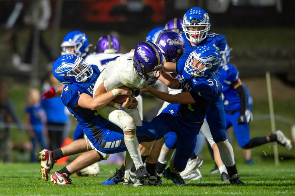 PHOTO BY FOREST WORGUM Elma defenders Andrew McClintock (51) and Donovan Kalakosky (54) tackle a Sequim player during a 28-7 loss on Friday at Elma High School.