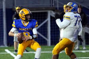 RYAN SPARKS | THE DAILY WORLD Aberdeen quarterback Mason Hill (left) prepares to throw while chased by Rochester defensive lineman Nicolas Mendiola during a 33-7 loss on Friday at Stewart Field in Aberdeen.