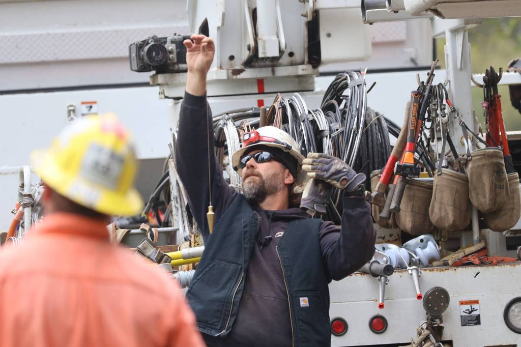 Michael S. Lockett / The Daily World
Line foreman Jason Johnson uses a plumb line to check a newly replaced pole against true.