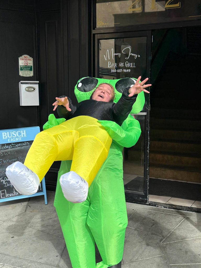 Jessica Knutson, owner of Messy Jessy's Bar and Grill, dresses as "Hammerhead," an alien who's dragging away a human being victim. Knutson loves dressing up for Halloween and she loves seeing all the children as they come down in fun and scary costumes. (Matthew N. Wells / The Daily World)