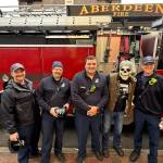 Wil Russoul, in the mask, stands with Aberdeen Fire Capt. Ryan Cline, John VanSyckle, Lorenzo Ontiveros and Trevor Wheeler. (Matthew N. Wells / The Daily World)