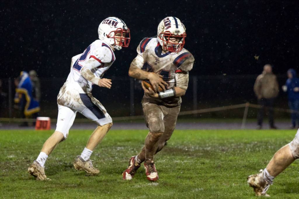 KODY CHRISTEN / THE CHRONICLE 
Pe Ell-Willapa Valley running back Lucas Lusk (right) runs the ball during a game on Oct. 31. The Titans travel north to face Friday Harbor in a 2B State first-round playoff game on Saturday.