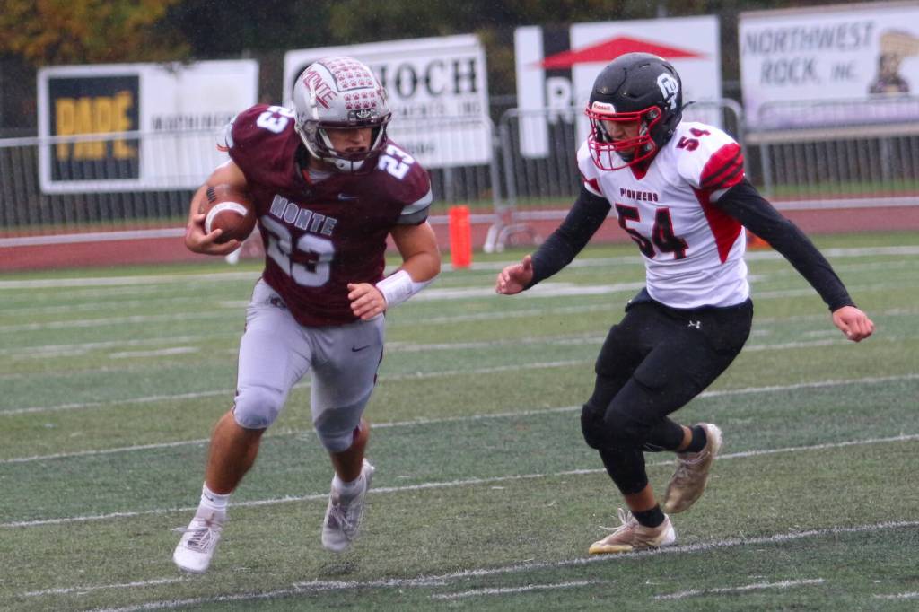 RYAN SPARKS | THE DAILY WORLD Montesanos Marcus Hale (23) sprints away from Omak linebacker Juan Duran during the Bulldogs 31-7 win in a 1A State Tournament playoff game on Saturday at Montesano High School.