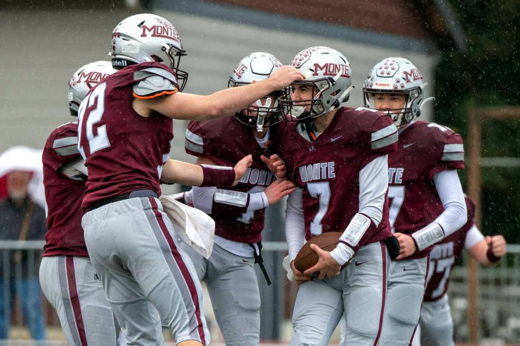 PHOTO BY FOREST WORGUM Montesano lineman Nathan Dowler (left) congratulates quarterback Tyson Perry (7) after a touchdown run during a 31-7 victory over Omak in a 1A State Tournament playoff game on Saturday at Montesano High School.