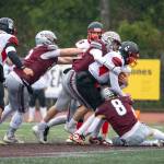 PHOTO BY FOREST WORGUM Montesano defenders Gabe Pyhala (middle), Mason Fry (8) and Felix Romero tackle Omak quarterback Teagen Mullin during the Bulldogs 31-7 victory in a 1A State Tournament playoff game on Saturday in Montesano.
