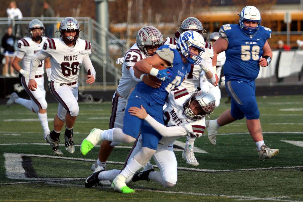 RYAN SPARKS | THE DAILY WORLD Montesano linebackers Kole Kjesbu (24) and Marcus Hale (23) tackle La Center running back Isaac Chromey during the Bulldogs 21-10 win in a 1A State Football quarterfinal game on Saturday at Woodland High School.