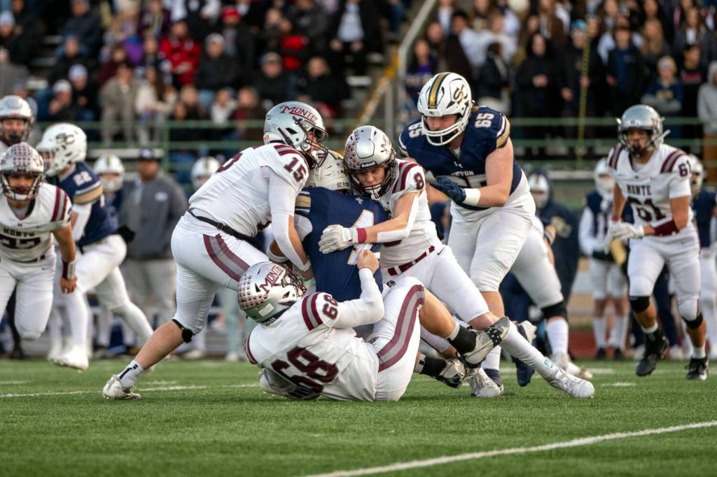PHOTO BY FOREST WORGUM Montesano defenders Felix Romero (15), Mason Fry (8) and Kyle Caton stop Seton Catholic running back Jacob Williams short of a first down during the Bulldogs 35-14 loss in a 1A State semifinal game on Saturday in Vancouver.