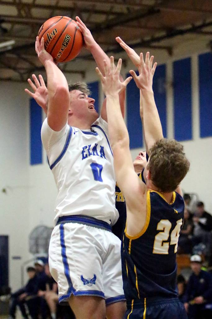 RYAN SPARKS | THE DAILY WORLD Elma senior guard Traden Carter (0) is defended by a pair of Forks Spartans during a 67-48 loss to Forks on Friday at Elma High School.