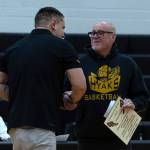 PHOTO BY MATT CYPHERT North Beach head coach Jordan Fry (left) congratulates former head coach Larry Moore during a ceremony to honor the Hyaks legend in a game against Northwest Christian on Saturday at North Beach High School.