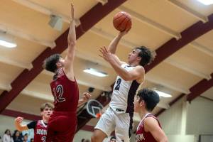 PHOTO BY FOREST WORGUM Raymond-South Bends Chris Banker (2) puts up a shot against Hoquiams Tage Dayton during the Grizzlies 57-44 win on Saturday at South Bend High School.