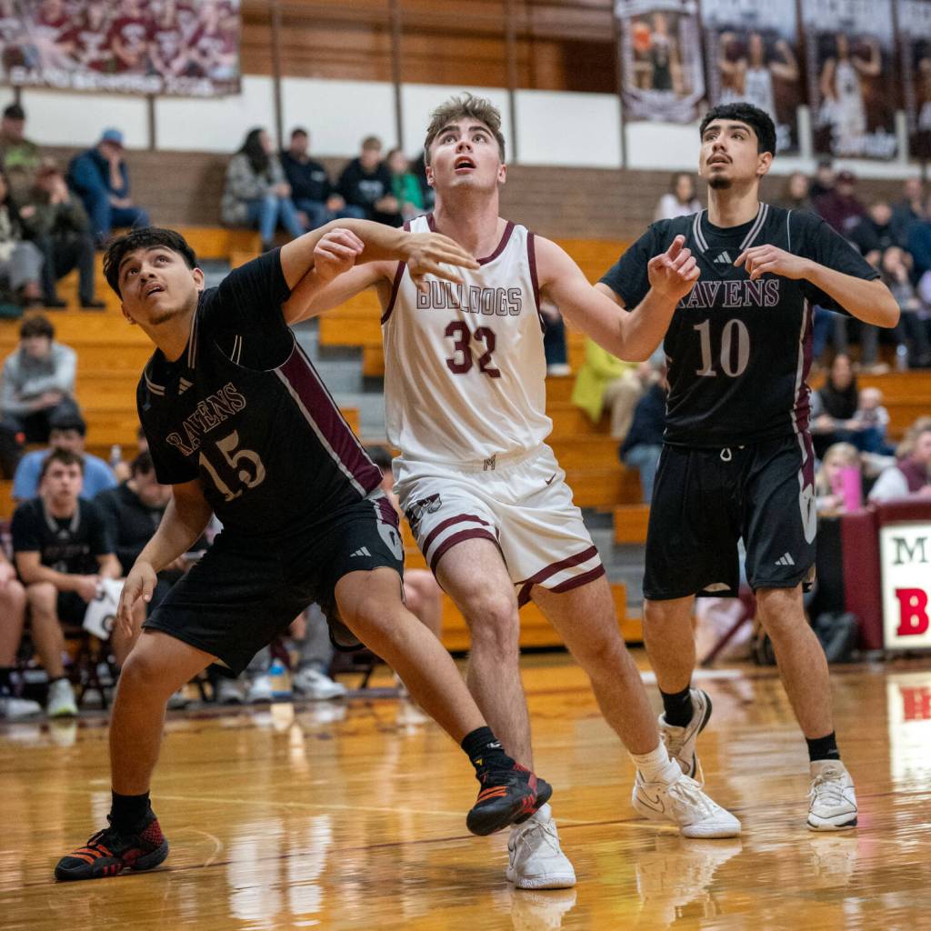 PHOTO BY FOREST WORGUM Raymond-South Bends Juan Sanchez Martinez (15) and Juan Orozco (10) compete for a rebound against Montesanos Nathan Dowler during the Bulldogs 57-40 win on Monday in Montesano.