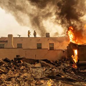 Jason Armond / Los Angeles Times / TNS
Firefighters fight the Eaton fire in Altadena on Wednesday, Jan. 8.