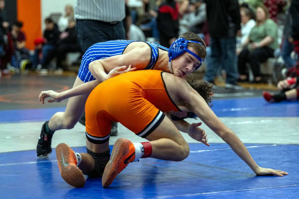 PHOTO BY FOREST WORGUM Elmas Aidyn Johnson (top) competes in the 120-pound weight class during the Sgt. Justin Norton Memorial Invitational on Saturday at Rainier High School.