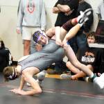 PHOTO BY SUE MICHALAK BUDSBERG Elmas Blaize Salazar (top) works a double-leg takedown against Montesanos Kole Kjesbu during the 144 pound first-place match at the Sgt. Justin Norton Memorial Invitational on Saturday at Rainier High School.