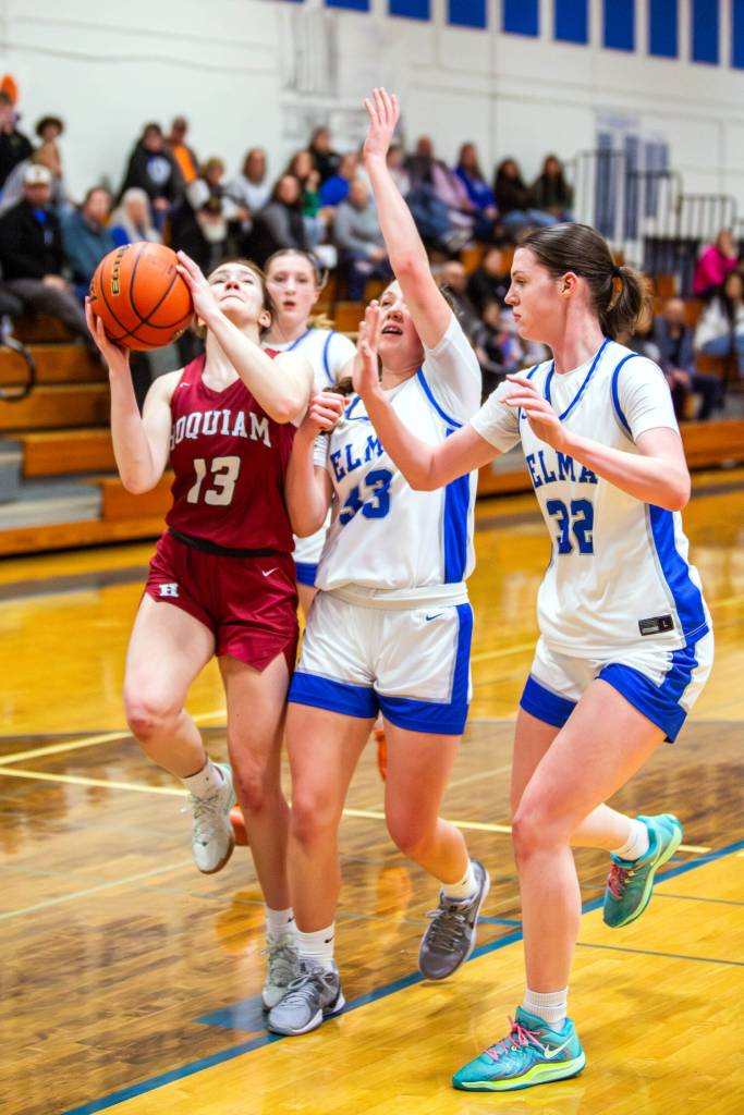 PHOTO BY MIKE ROBERTS Hoquiams Katlyn Brodhead (13) drives to the basket while Elmas Olivia Moore (33) and Emily Escoffon defend during the Grizzlies 49-27 win on Tuesday in Elma.