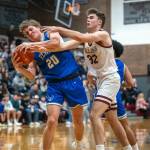PHOTO BY FOREST WORGUM Elmas Dylan Myer (20) keeps the ball away from Montesanos Nathan Dowler (32) during the Bulldogs 47-33 victory on Friday at Montesano High School.