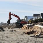 Photos by Jerry Knaak
A backhoe operator lays cobble for the new berm along the south shore beach in Ocean Shores.