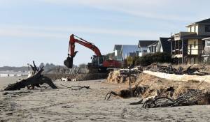 Photos by Jerry Knaak
A backhoe operator lays cobble for the new berm along the south shore beach in Ocean Shores.