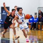 PHOTO BY MIKE ROBERTS Elma point guard Theo Flores (5) dribbles against Rainiers Nehemiah Linson during the Eagles 48-33 win on Monday at Elma High School.