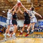 PHOTO BY MIKE ROBERTS Elmas Isaac McGaffey (far left) and Spencer Olsen (24) compete for a rebound against Rainiers Peyton Sheaffer (22) and Jordan Pringle during the Eagles 48-33 win on Monday at Elma High School.