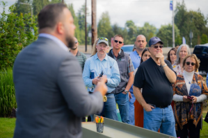 Summit Pacific Medical Center CEO Josh Martin addresses campaign supporters at the signing of the final steel beam that will support the new structure of their expansion. Nate Root, Log Procurement Manager with Murphy Company and President of the Summit Pacific Medical Foundation Board, is in attendance (middle). (Summit Pacific Medical Center)