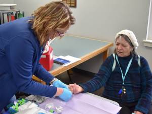 Grays Harbor County Public Health Nurse Lena Stoddard prepares to test the blood sugar of an Elma resident. (Jerry Knaak photos / The Daily World)