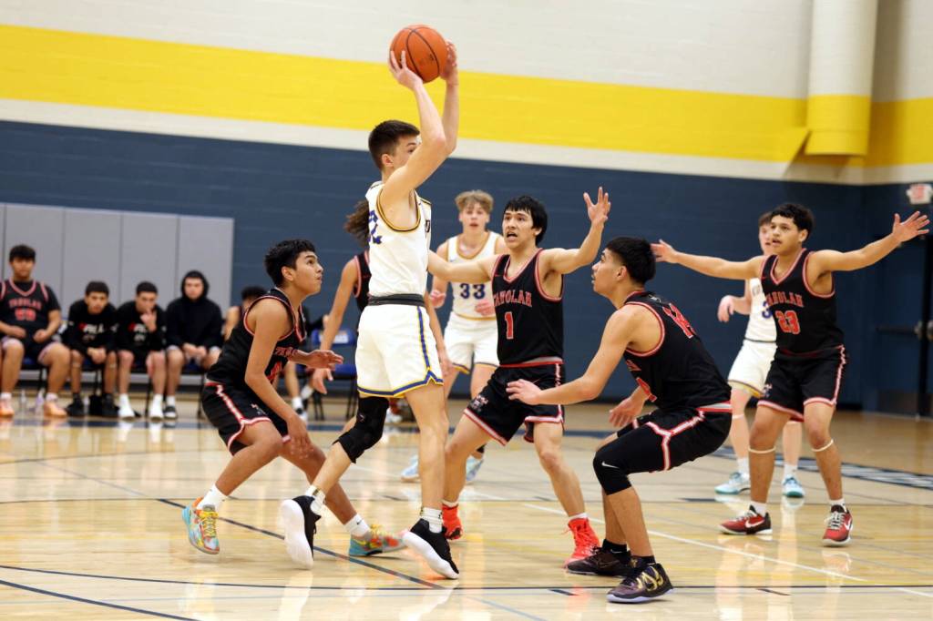 PHOTO BY TIA CHENEY Taholah defenders (from left) Domonique Rodriguez, Jayden Lewis and Jade Charley surround Columbia Adventists Luke Pierce during the Chitwhins 68-51 loss in the 1B District 4 Tournament on Wednesday in Battle Ground.