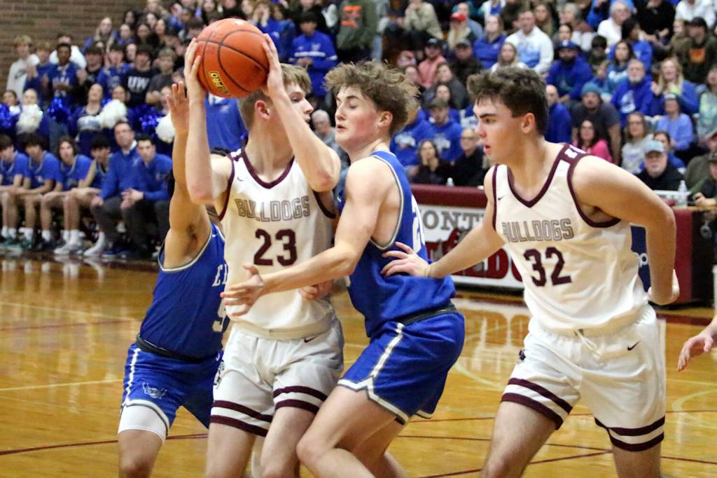 RYAN SPARKS | THE DAILY WORLD Montesanos Caden Grubb (23) is defended by Elmas Dylan Myer while Montes Nathan Dowler looks on during the Eagles 49-48 victory on a 1A District 4 elimination game on Wednesday at Montesano High School.