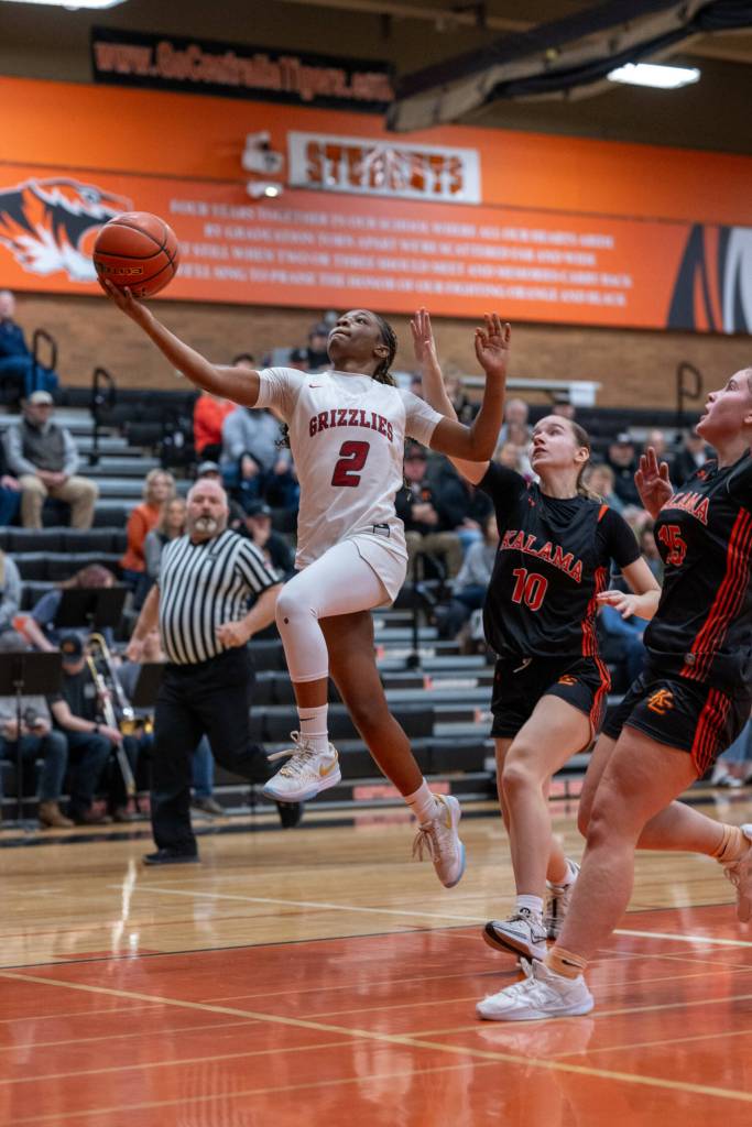 PHOTO BY FOREST WORGUM Hoquiam guard RenaèJah (2) soars to the basket while pursued by Kalamas Rylie Cadigan (10) and Delaney Rinard during the Grizzlies 43-37 1A District 4 elimination game on Saturday in Centralia.