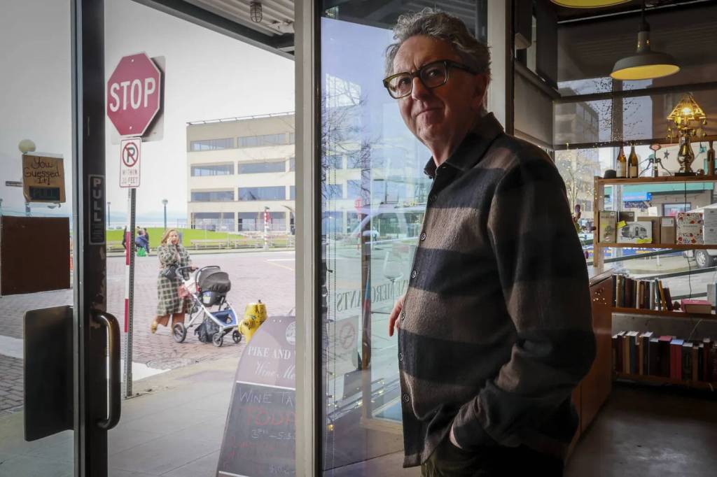 Kevin Clark / The Seattle Times
Michael Teer, owner of Pike and Western Wine Shop, has watched the ebb and flow of Victor Steinbrueck Park, which draws crowds of tourists and locals on sunny summer days.