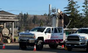 A technician assembles a temporary cell phone-receiving station in north county after an intense windstorm damaged one of the area’s primary towers, affecting service to thousands. (Jeff Clemens / Chinook Observer)