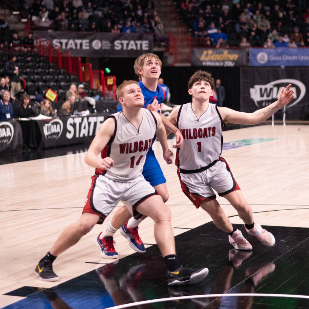 PHOTO BY TIA CHANNELL Ocostas Kayden Turner (14) and Dalton Welch (1) compete for a rebound against Willapa Valleys J.B. Russell during the Vikings 51-46 win in a 1B State Tournament elimination game on Friday at the Spokane Arena.