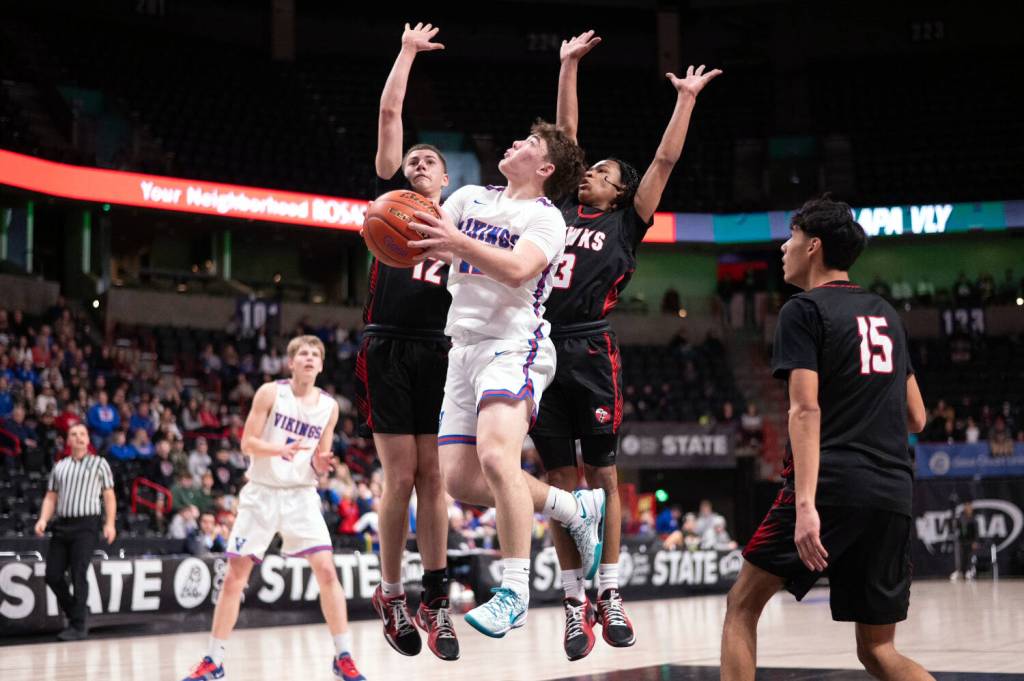 PHOTO BY TIA CHANNELL Willapa Valleys Lucas Lusk (middle) puts up a shot against Tulalip Heritages David Bachand (12) and Jaylan Gray (3) during a 64-46 loss in the 1B State Tournament fourth/sixth-place game on Saturday at the Spokane Arena.