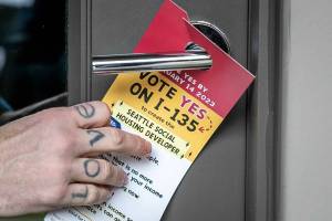 Kevin Clark / The Seattle Times
A flyer urging a yes vote on a 2023 citizen led initiative is left at a home in Seattle.