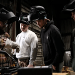 Skills & Drills workshop participants watch a stick welding demonstration.