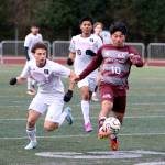 RYAN SPARKS | THE DAILY WORLD Montesanos Cris Tobar boots the ball forward while pursued by Raymond-South Bends Alex Posada during the Ravens 6-0 win on Thursday at Jack Rottle Field in Montesano.