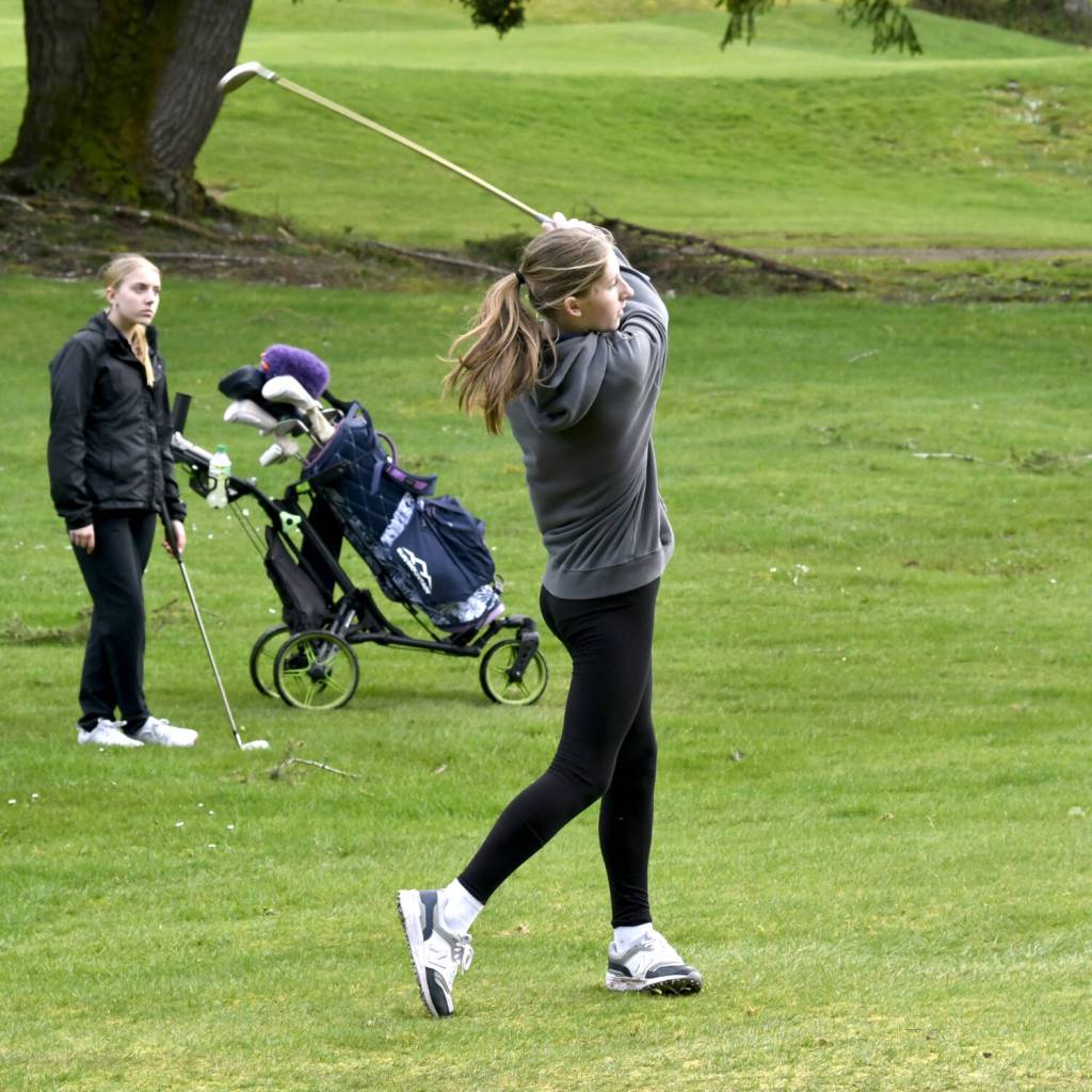 SUBMITTED PHOTO Aberdeen golfer Kennedy Kolodzie hits from the fairway as teammate Shay Dunlap looks on during a match at Tumwater Valley Golf Course this week.