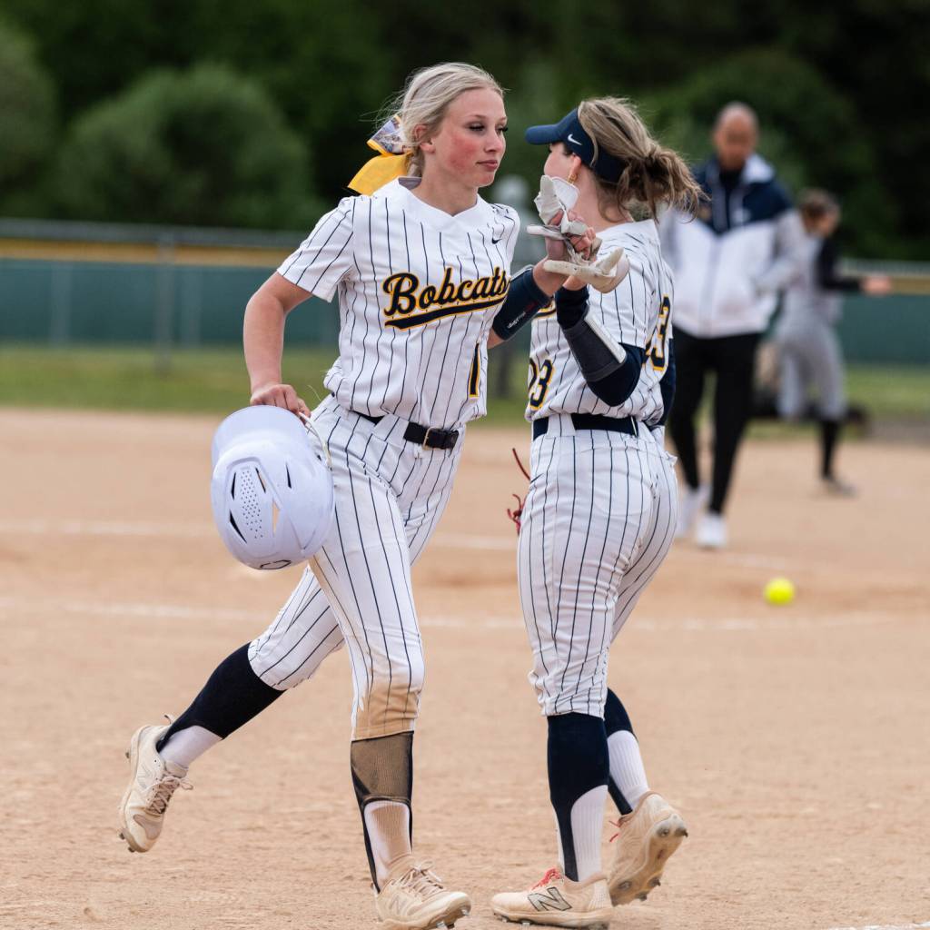 ALICIA TISDALE | ALICIA TISDALE PHOTOGRAPHY Aberdeens Zoe Vessey (left) gets a high five from Kadence Braaten during an 11-1 win over Centralia on Monday at Stewart Field in Aberdeen. Vessey hit a walk-off home run to secure the Bobcats mercy-rule win.