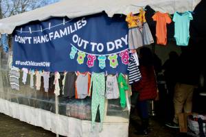 Julia Shumway / Oregon Capital Chronicle
Advocates who urged the Oregon Legislature to increase child care funding in January 2024 hung onesies and other childrens clothes on a tent outside the Capitol in Salem. They planned to donate the clothes after Thursdays demonstration.