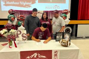 SUBMITTED PHOTO 
Ocostas Matthew Wyland (sitting) signs a National Letter of Intent to play football at the University of Puget Sound at a ceremony on Saturday at Ocosta High School. Standing are (from left) father Rob Wyland, mother Nicole Gentile and stepfather Matt Gentile.