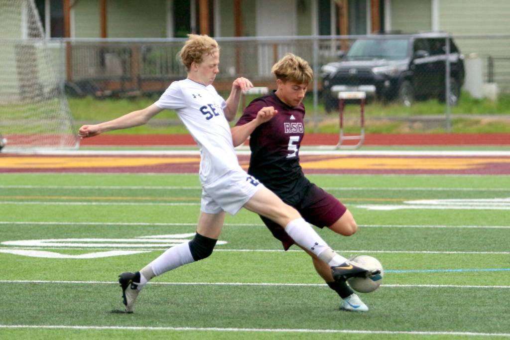 RYAN SPARKS | THE DAILY WORLD Raymond-South Bends Alex Posada (5) is defended by Seton Catholics Tynan Young-Byle during a 1A District 4 semifinal game on Tuesday at South Bend High School.