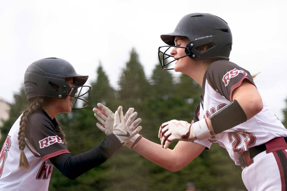 KODY CHRISTEN | THE CHRONICLE Raymond-South Bends Josie Houk (left) and Tressa McMullen share a high-five during the Ravens 10-0 win over Adna in a 2B District 4 semifinal game on Wednesday in Centralia.