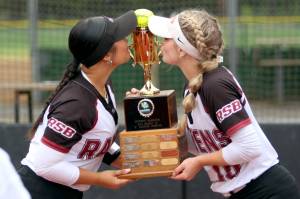 RYAN SPARKS | THE DAILY WORLD Raymond-South Bends Berklee Morley (left) and Emma Glazier kiss the 2B District 4 championship trophy on Friday at Fort Borst Park in Centralia.