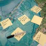 A map depicting potential future flood conditions in the vicinity of Skidmore Slough is dotted with workshop participants sticky notes.