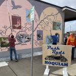 Push Rods Car Club members paint a protective coat on the mural.