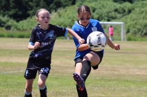 PHOTO BY LORI VALENTINE A player from the Grays Harbor Gulls Blue team (left) battles for possession against a player from the Elma McCleary Football Club during a girls 11 and under match at the Coastal Cup on Saturday in Aberdeen.